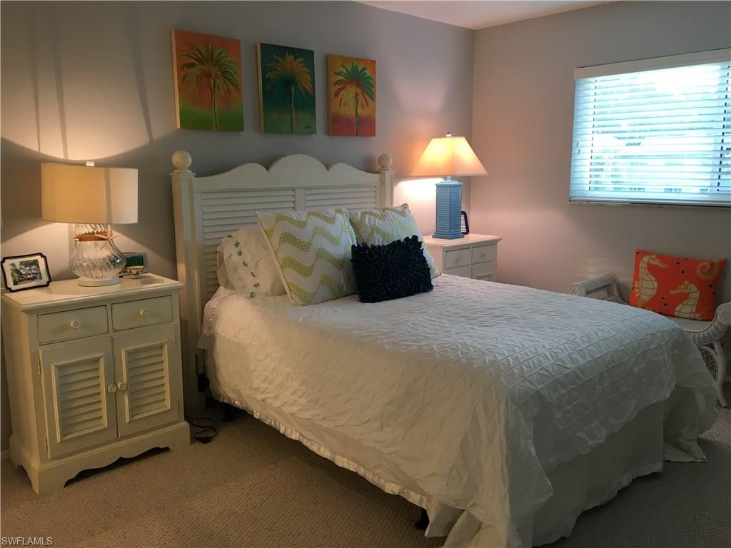 4140 Crayton Road, Unit D6 Naples, FL 34103 - Photo 8 of 14 a bedroom with a bed and a lamp