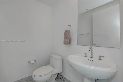 a bathroom with a sink a toilet and mirror