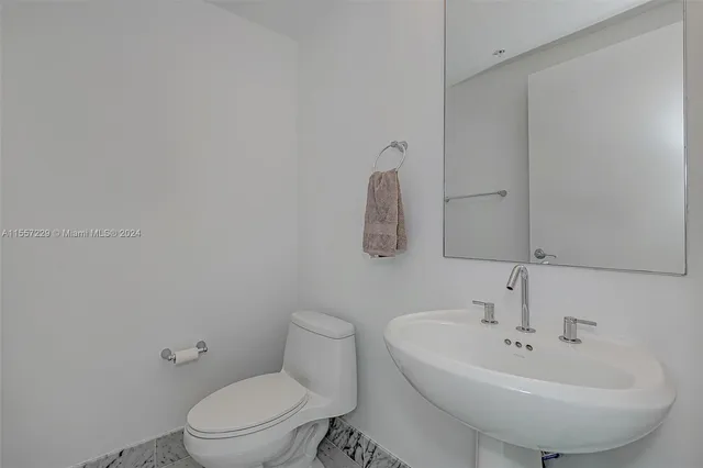 a bathroom with a sink a toilet and mirror
