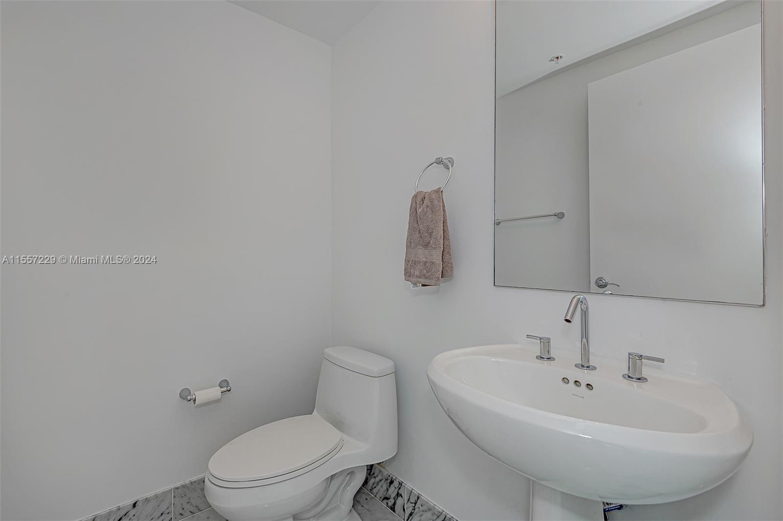 244 Biscayne Boulevard, Unit UPH4907 Miami, FL 33132 - Photo 30 of 38 a bathroom with a sink a toilet and mirror