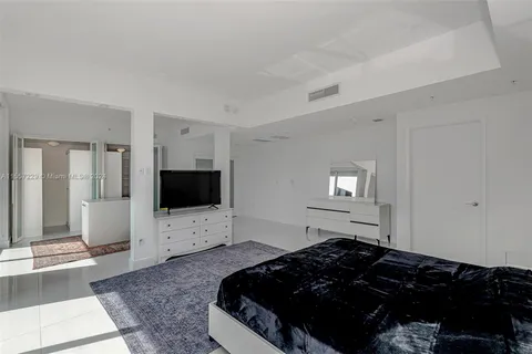 a bedroom with bed and flat screen tv