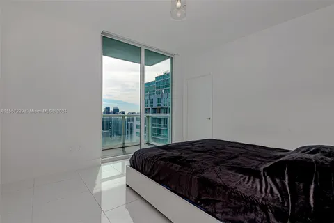 a bedroom with a bed and glass door