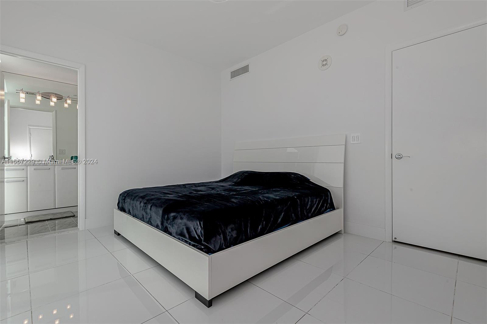 244 Biscayne Boulevard, Unit UPH4907 Miami, FL 33132 - Photo 35 of 38 a bedroom with a bed and window