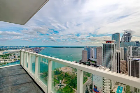 a view of a balcony with wooden floor & fence