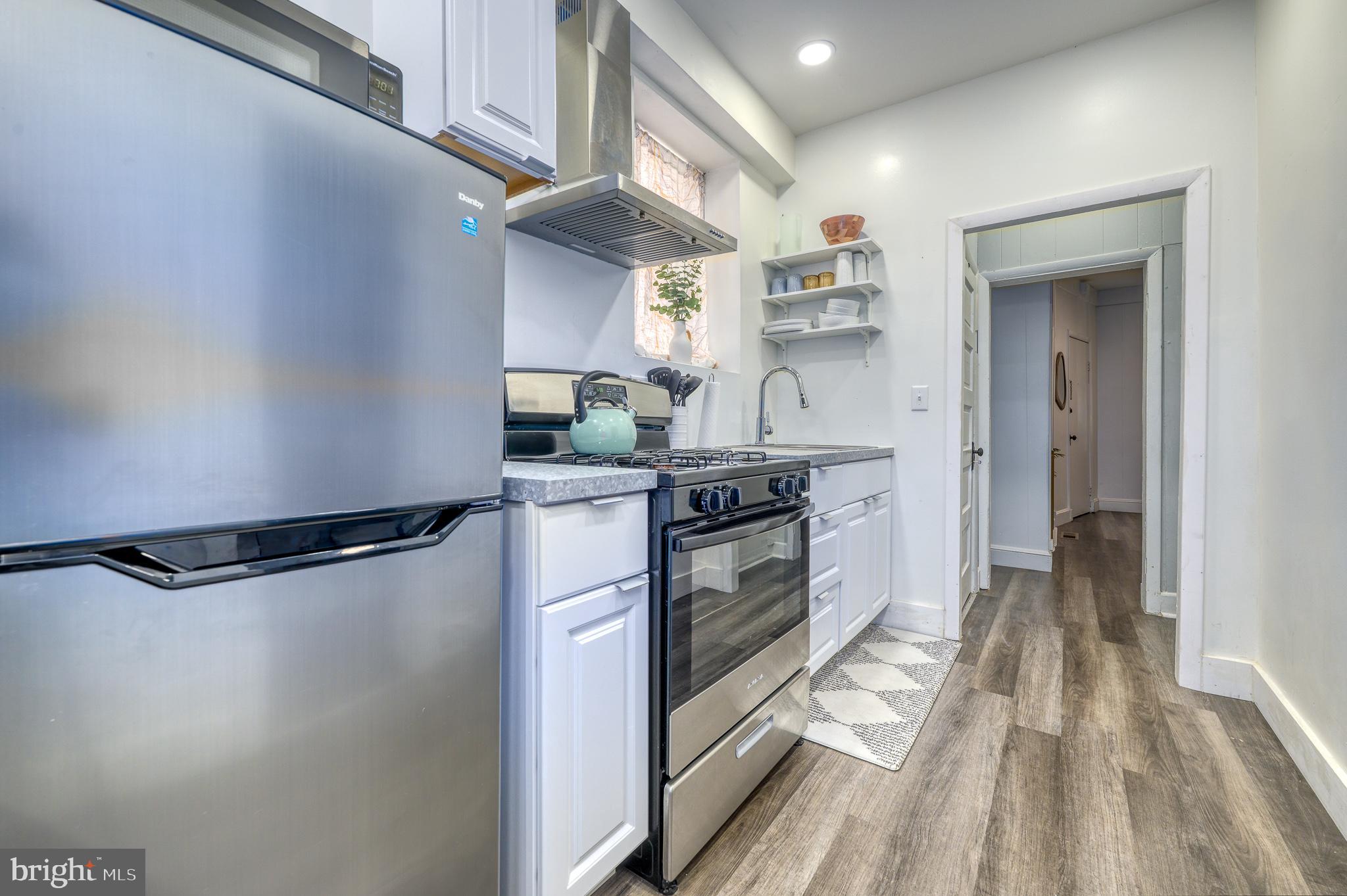 7104 Harford Road Baltimore, MD 21234 - Photo 28 of 37 a kitchen with stainless steel appliances a refrigerator a sink and white cabinets