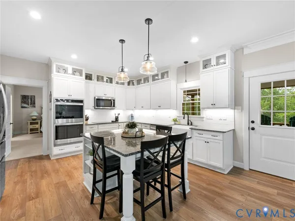 a very nice looking kitchen with granite countertop a stove a sink a window and dining table