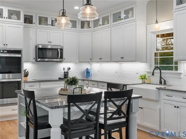 a kitchen with stainless steel appliances granite countertop a kitchen island a stove a table and chairs in it