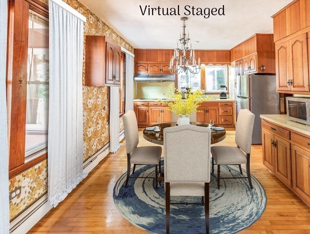 91 Edgewater Road Hull, MA 02045 - Photo 12 of 41 a dining room with furniture a floor to ceiling window and kitchen view