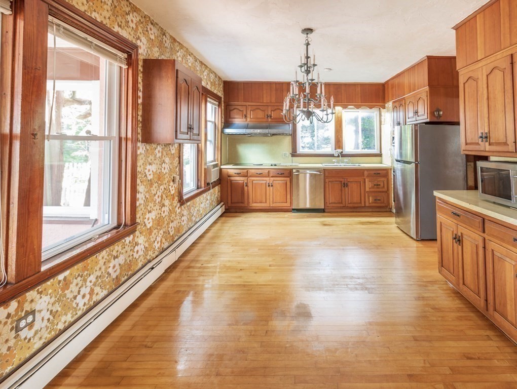 91 Edgewater Road Hull, MA 02045 - Photo 13 of 41 a view of a kitchen with stainless steel appliances wooden floor and a large window
