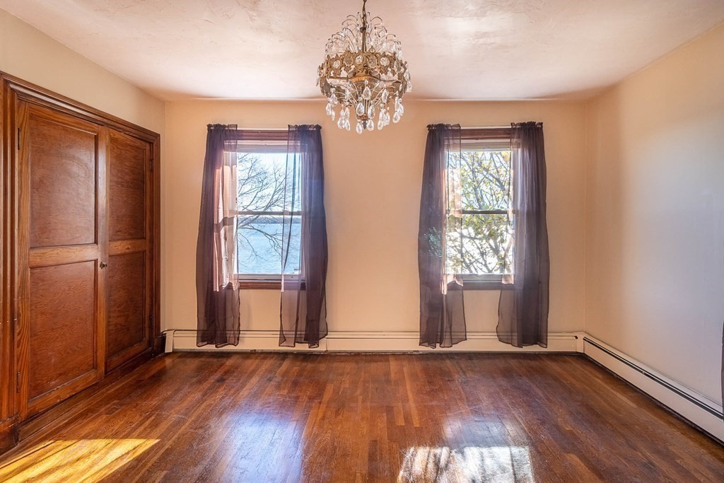 91 Edgewater Road Hull, MA 02045 - Photo 22 of 41 a view of an empty room with wooden floor and a window
