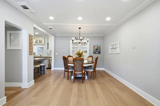 a dining room with furniture a chandelier and wooden floor