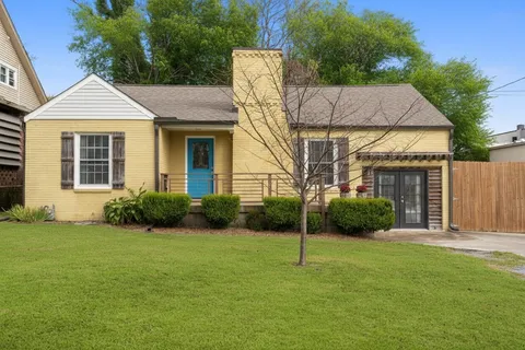 a view of a house with a backyard and a tree