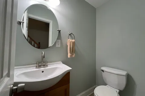 a bathroom with a toilet sink and mirror