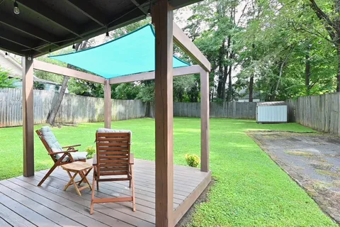 a view of a chair and table in backyard of the house
