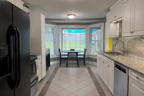 a kitchen with granite countertop a sink stove and refrigerator