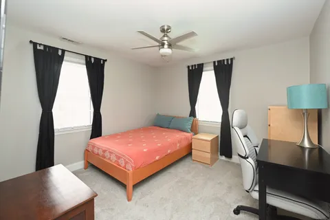 a bedroom with a bed window and table