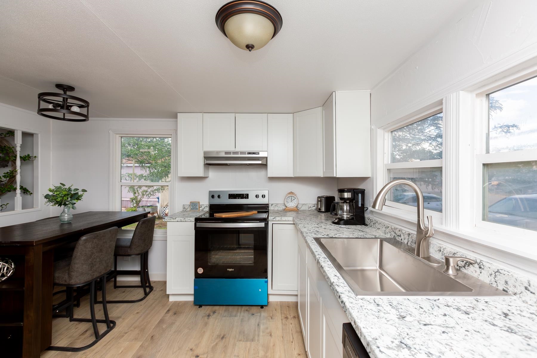 424 32 Road, Unit 112 Clifton, CO 81520 - Photo 10 of 41 a kitchen with stainless steel appliances granite countertop a sink dishwasher stove a refrigerator with wooden cabinets and wooden floor