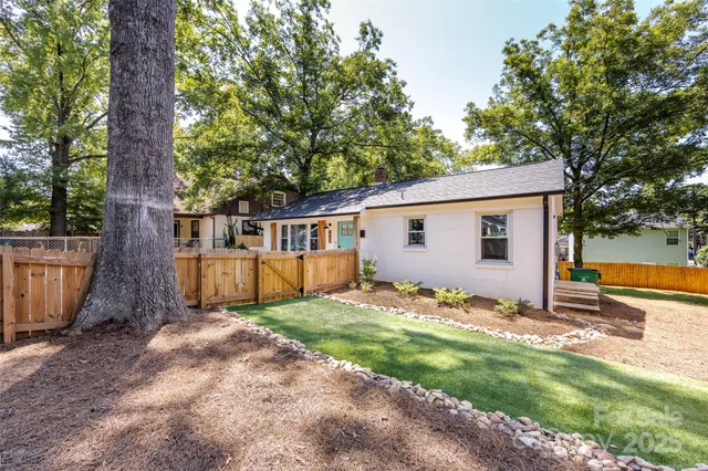 a view of a house with backyard and a tree
