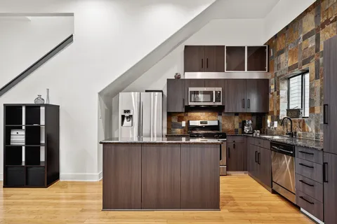 a kitchen with stainless steel appliances granite countertop a stove and cabinets