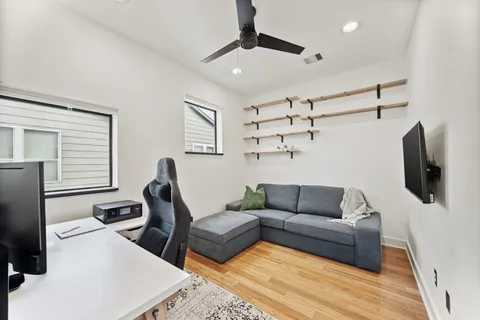 a living room with furniture a flat screen tv and a window