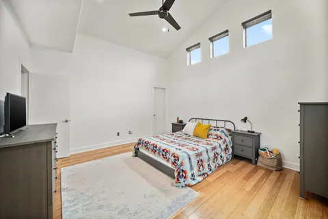 a bedroom with a bed and a flat tv screen on the dresser
