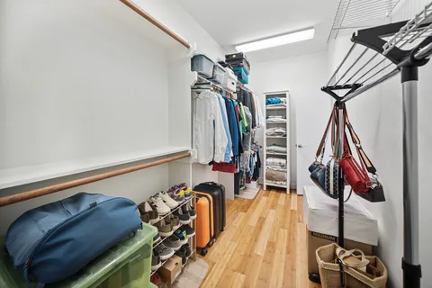 a view of walk in closet with clothes and shoes