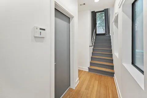 a view of a hallway with wooden floor and staircase