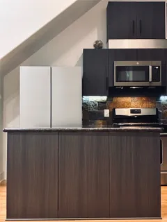 a kitchen with granite countertop a stove and a microwave