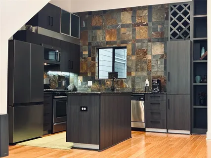 a kitchen with granite countertop a refrigerator and a sink