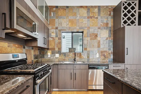 a kitchen with granite countertop a stove and a sink