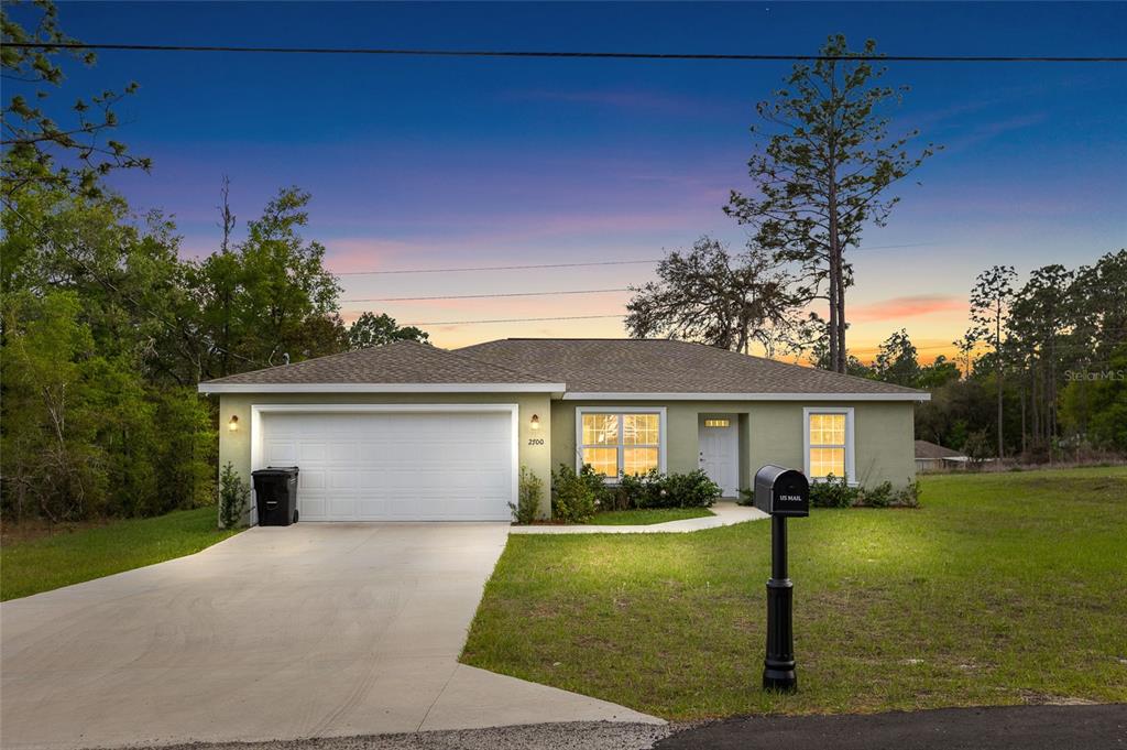 2700 West Rutland Drive Citrus Springs, FL 34434 - Photo 1 of 31 a front view of a house with a yard and garage