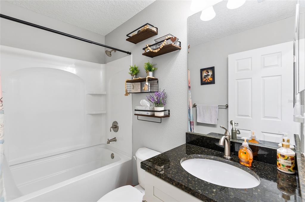 2700 West Rutland Drive Citrus Springs, FL 34434 - Photo 19 of 31 a bathroom with a granite countertop sink a toilet and bathtub