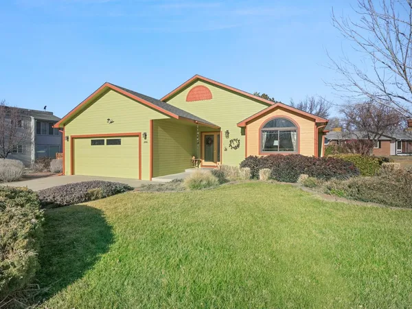 a front view of a house with a garden and yard