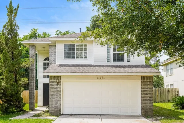 a front view of a house with a yard garage and outdoor seating