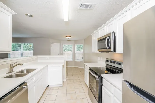 a kitchen with a sink stove top oven and microwave