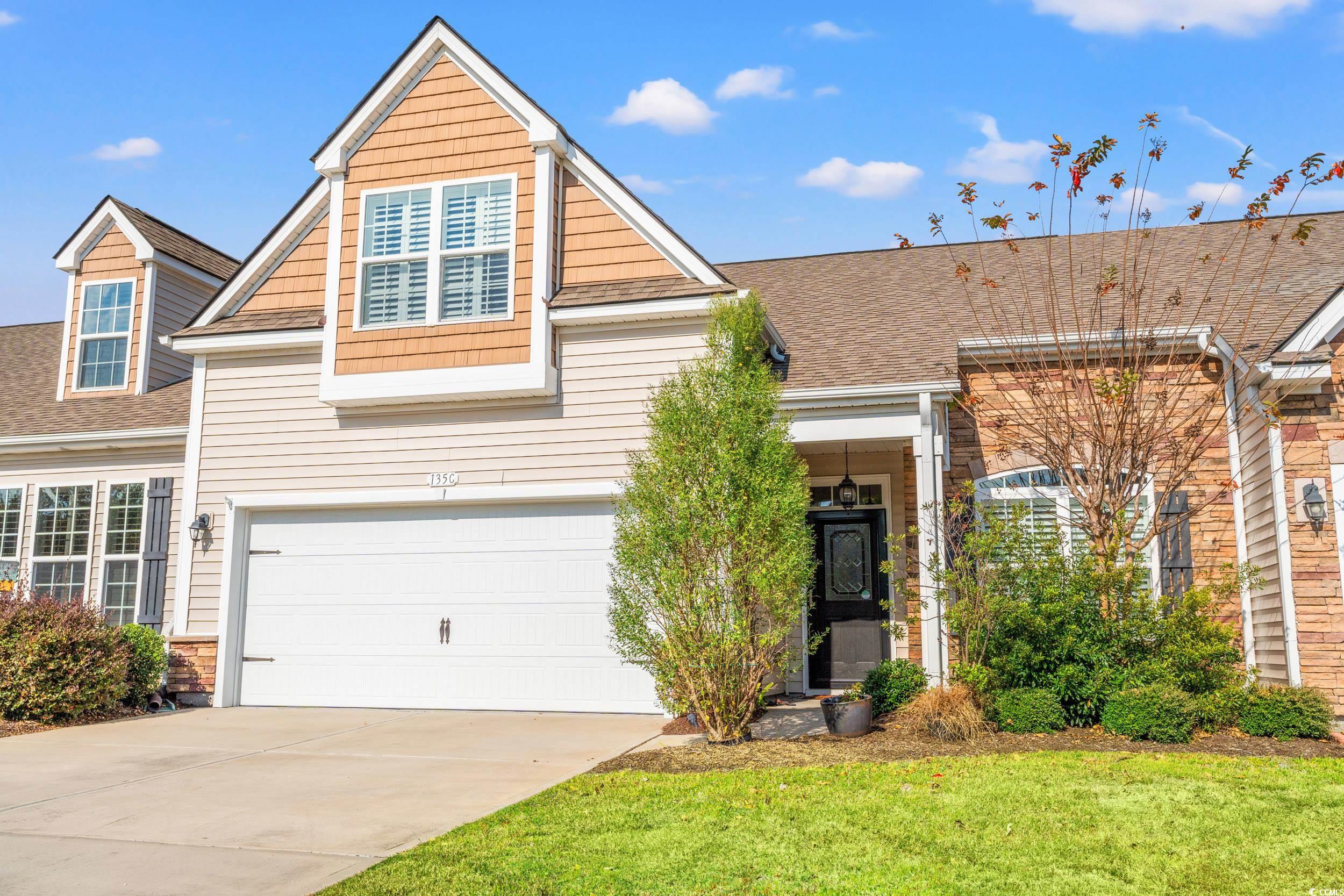 View of front of property with concrete driveway, a shingled roof, an attached garage, and a front lawn