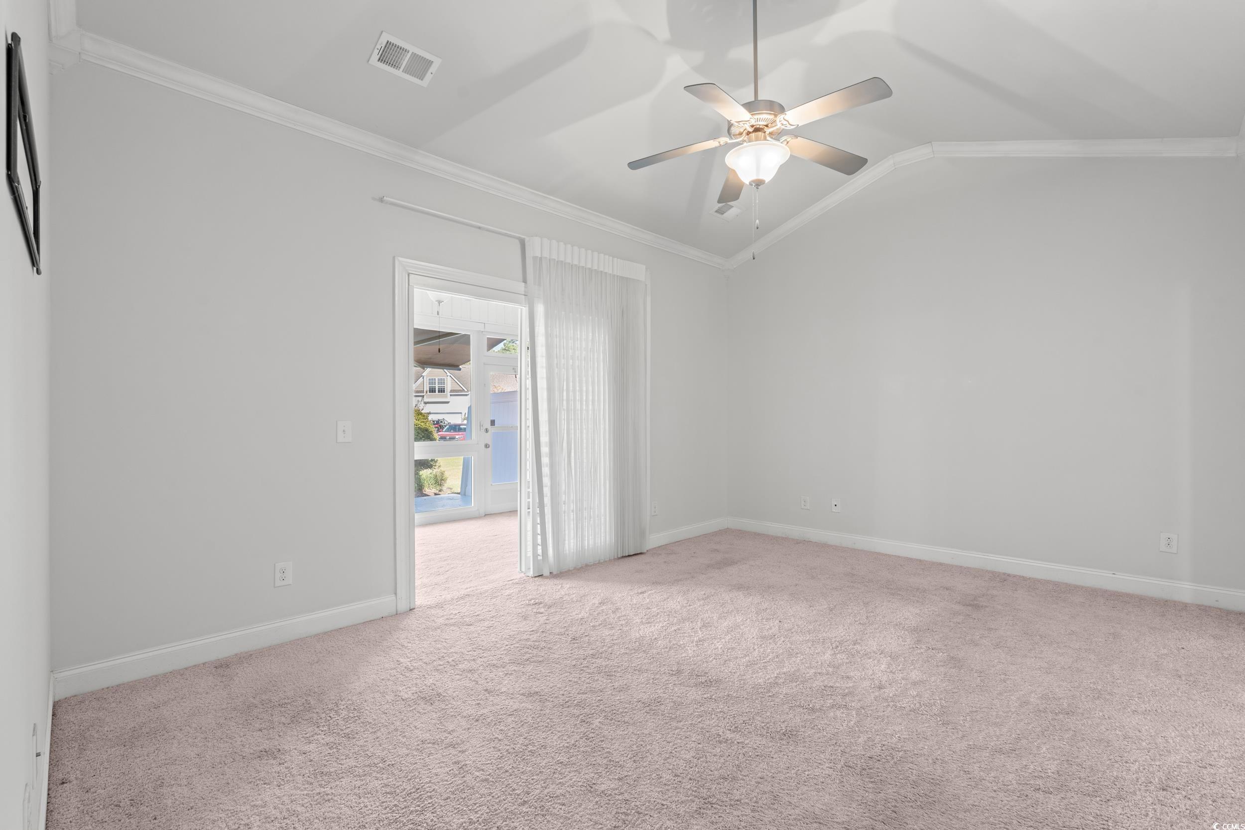 135 Parmelee Drive, Unit C Murrells Inlet, SC 29576 - Photo 17 of 37 Unfurnished room featuring crown molding, light colored carpet, vaulted ceiling, and a ceiling fan