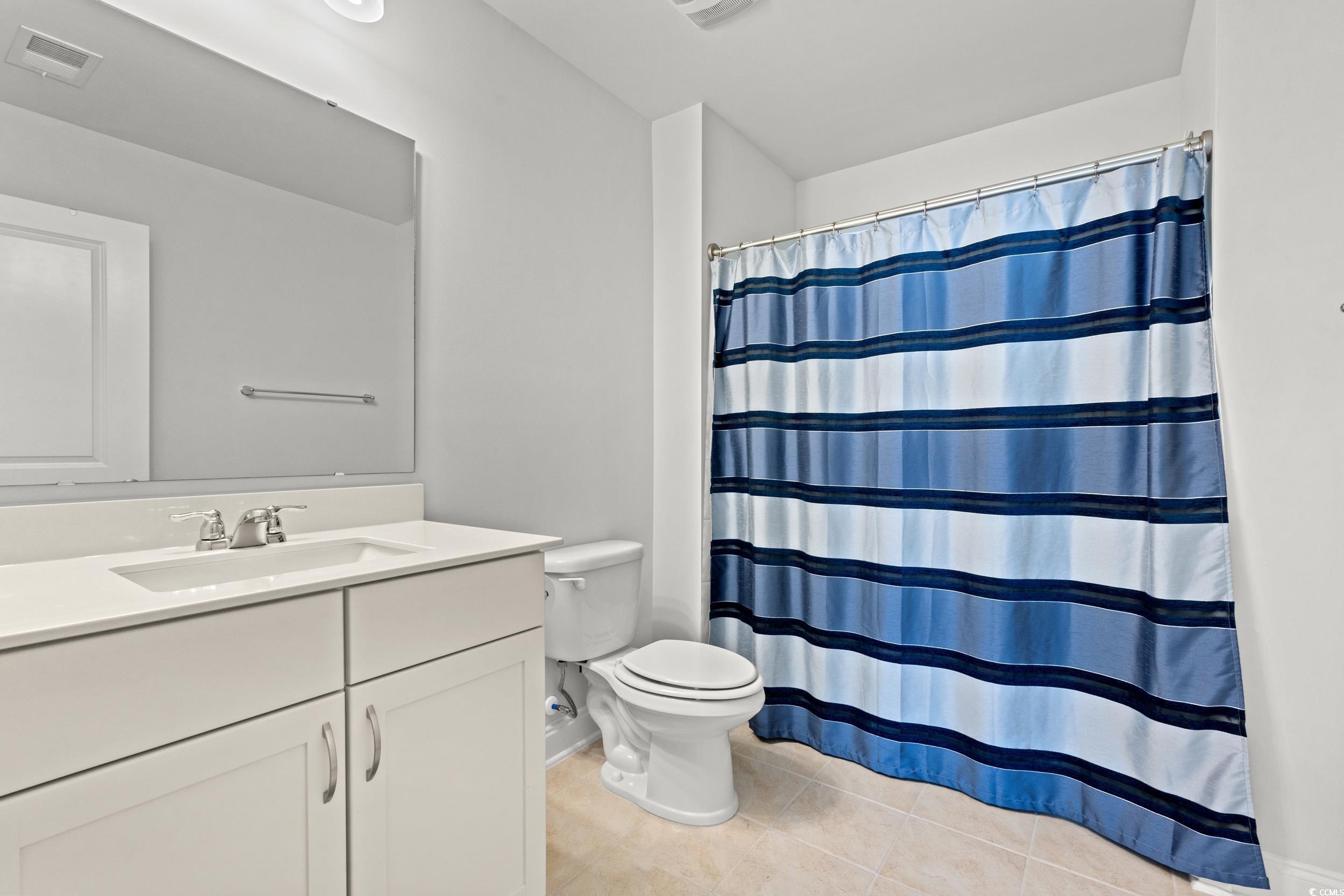 135 Parmelee Drive, Unit C Murrells Inlet, SC 29576 - Photo 25 of 37 Bathroom featuring a shower with shower curtain, vanity, and light tile patterned flooring