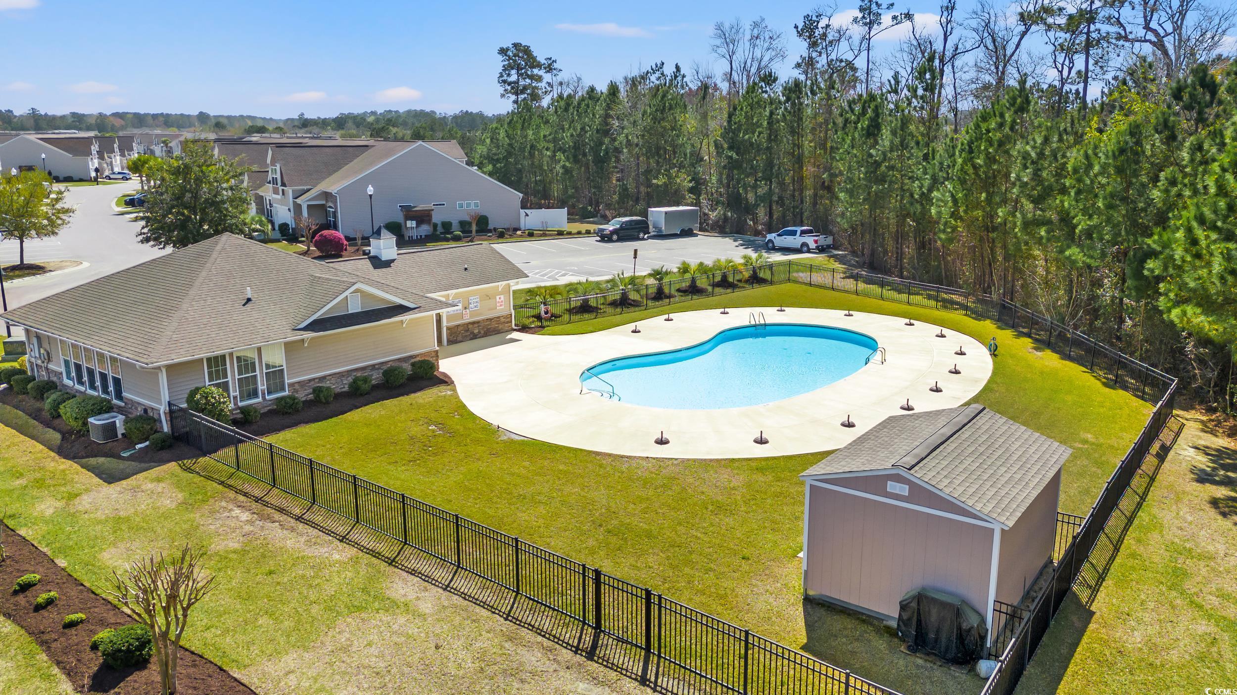 135 Parmelee Drive, Unit C Murrells Inlet, SC 29576 - Photo 32 of 37 View of swimming pool featuring a patio, a fenced backyard, and a shed