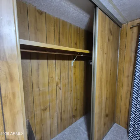 an empty room with closet and a ceiling fan