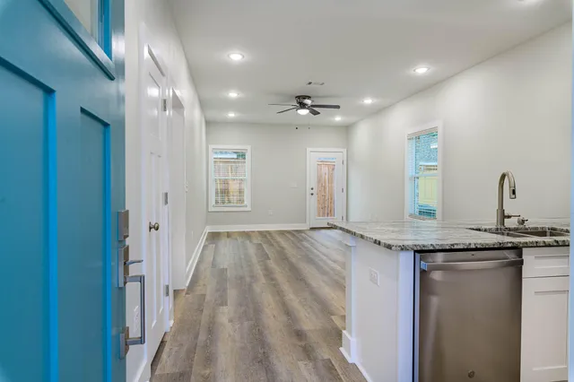 a kitchen with granite countertop a refrigerator and a stove top oven