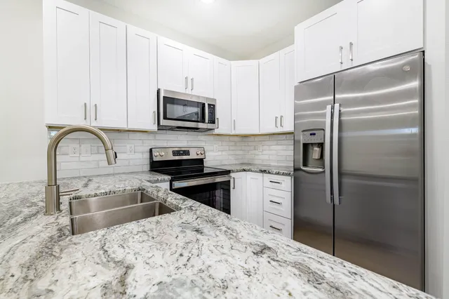 a kitchen with granite countertop a sink and a stove