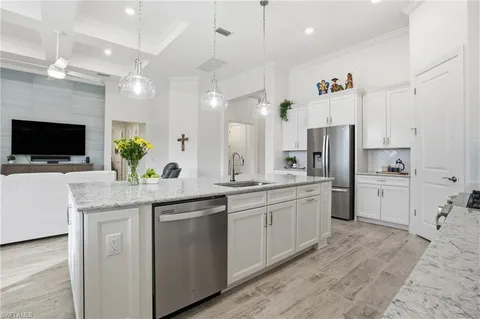 a kitchen with white cabinets and refrigerator