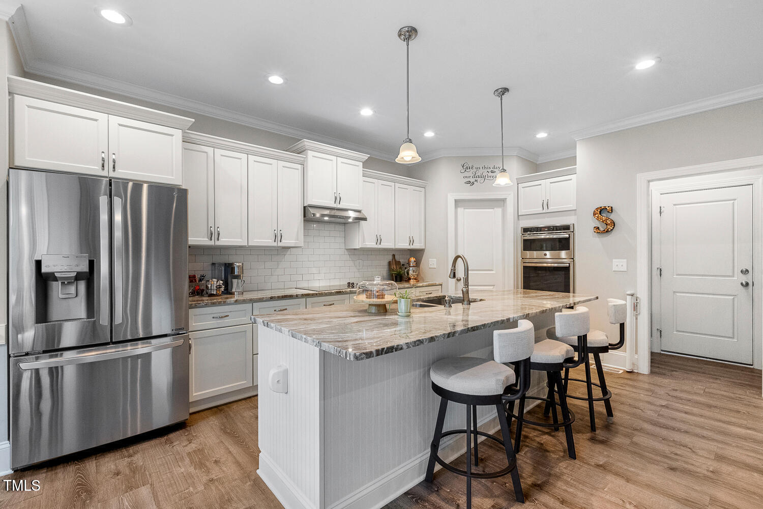 830 Wilbon Road Holly Springs, NC 27540 - Photo 13 of 60 a kitchen with stainless steel appliances granite countertop a stove a sink a refrigerator and white cabinets with wooden floor