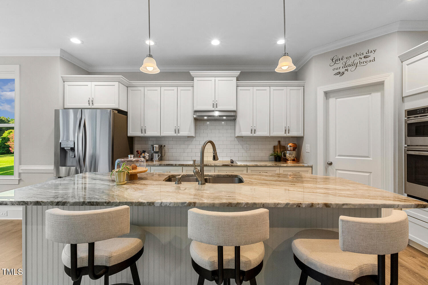 830 Wilbon Road Holly Springs, NC 27540 - Photo 14 of 60 a kitchen with kitchen island granite countertop a dining table chairs refrigerator and microwave
