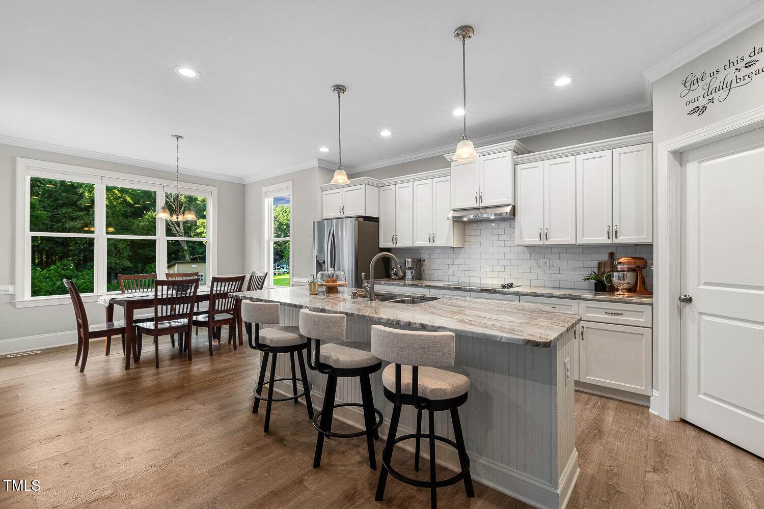 830 Wilbon Road Holly Springs, NC 27540 - Photo 20 of 60 a kitchen with kitchen island granite countertop a dining table chairs and white cabinets