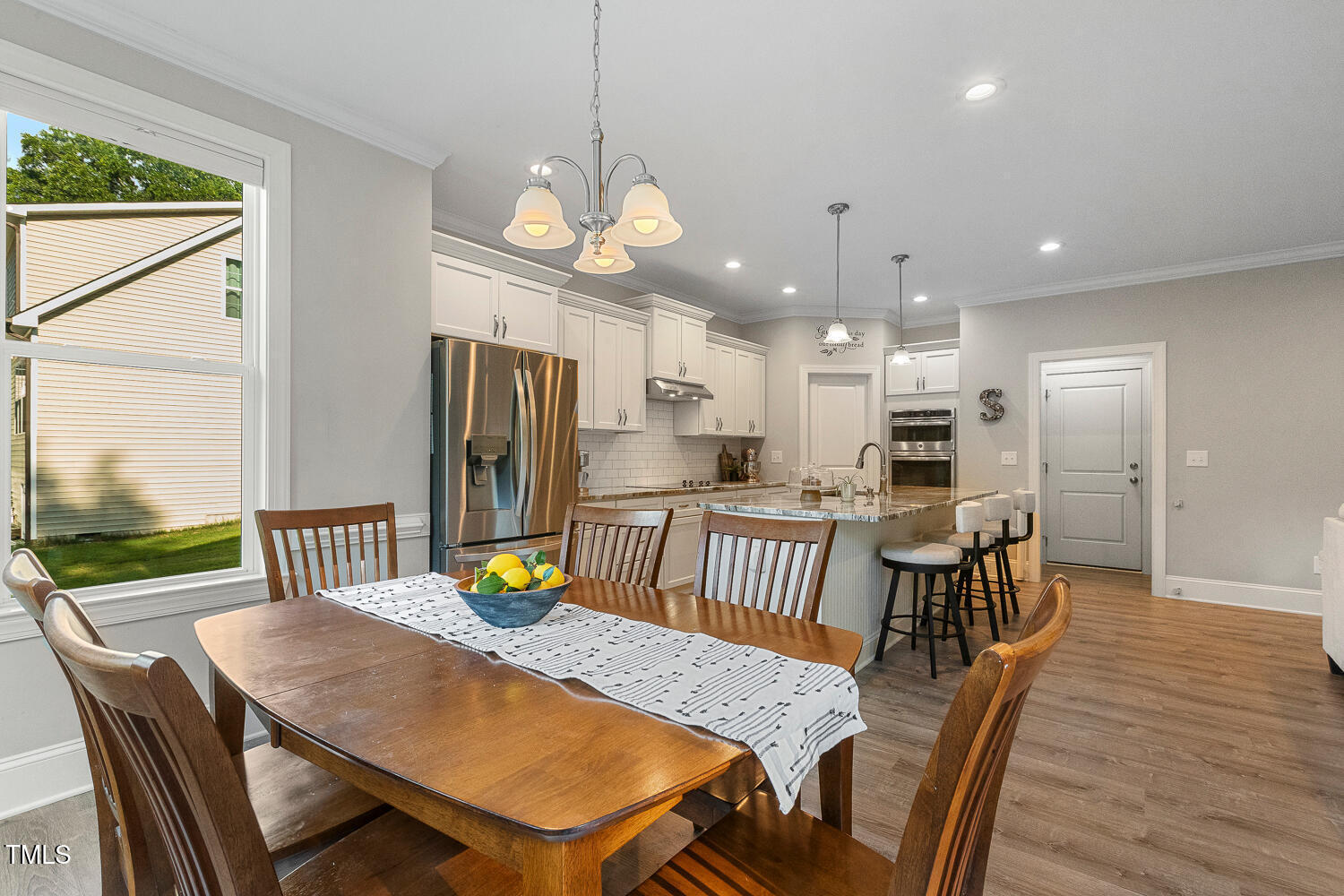 830 Wilbon Road Holly Springs, NC 27540 - Photo 23 of 60 a view of a dining room with furniture a chandelier and wooden floor