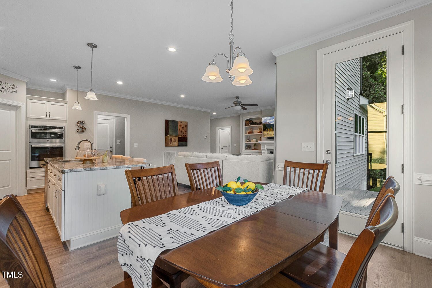 830 Wilbon Road Holly Springs, NC 27540 - Photo 24 of 60 a view of a dining room with furniture a chandelier and wooden floor