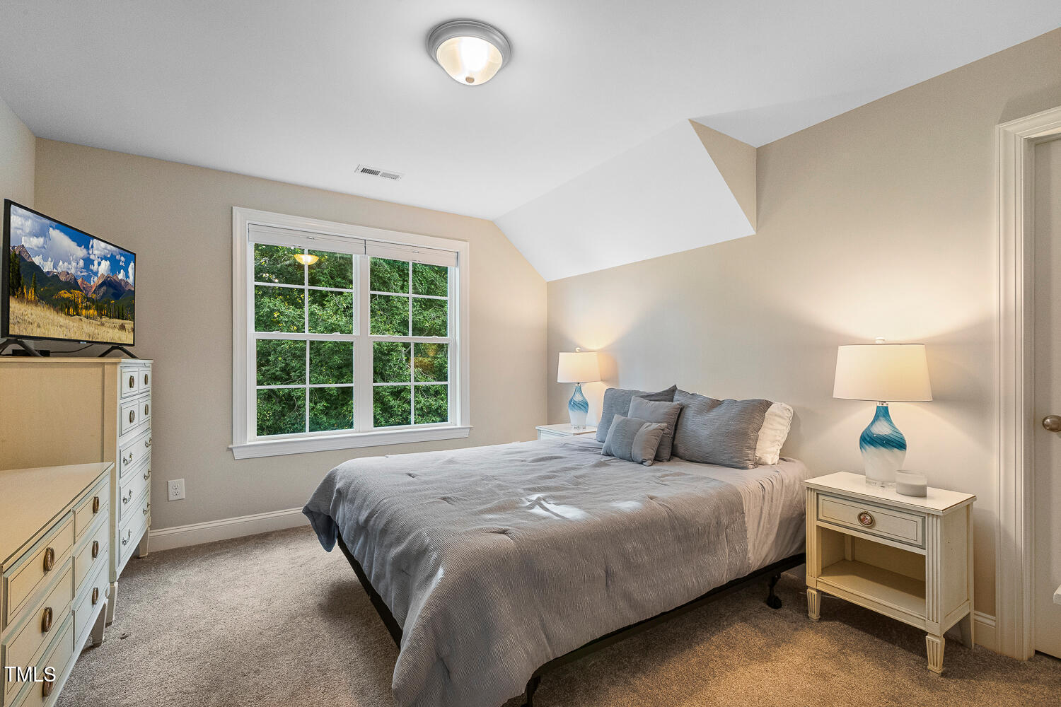 830 Wilbon Road Holly Springs, NC 27540 - Photo 37 of 60 a bedroom with a bed and a flat tv screen on dresser