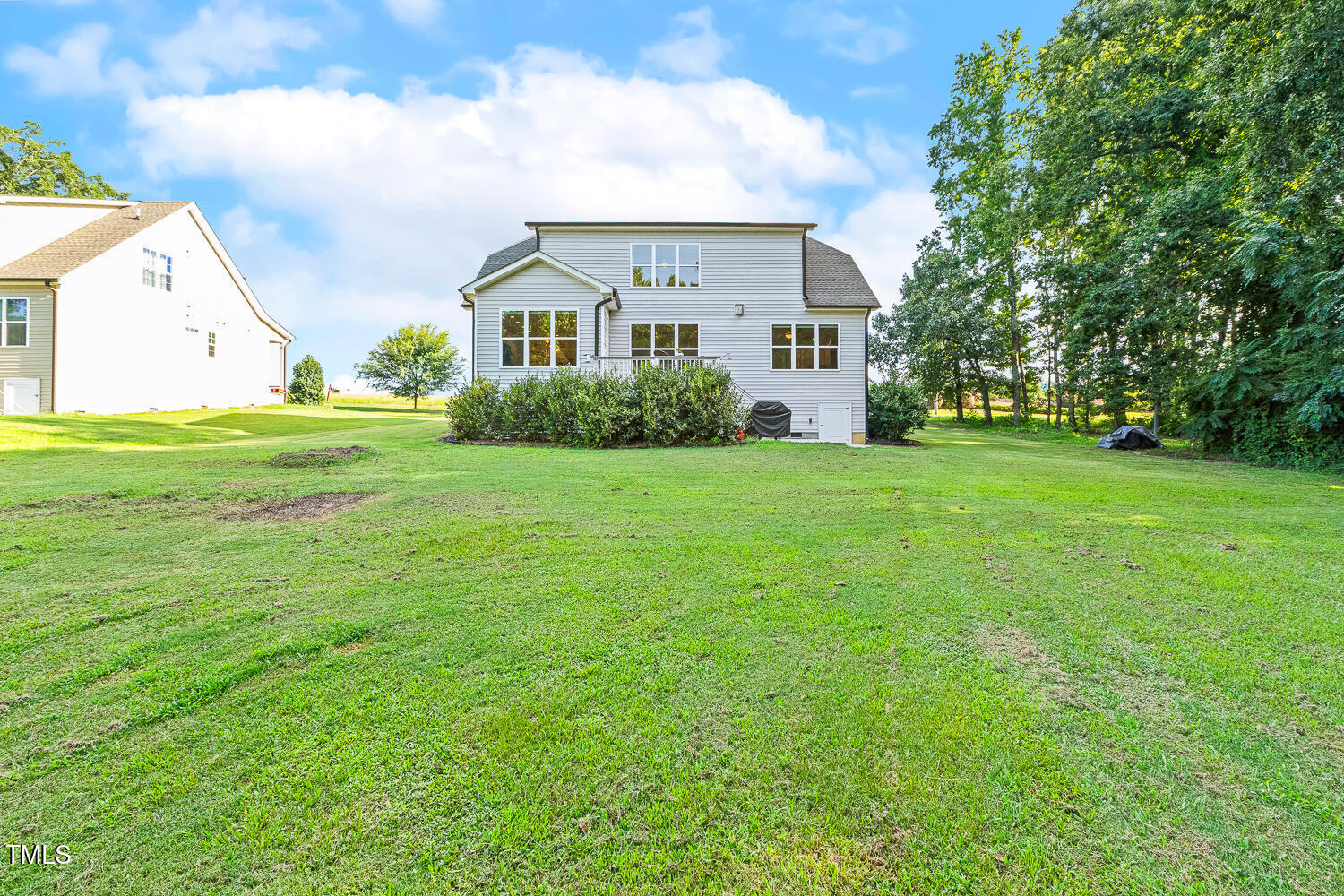 830 Wilbon Road Holly Springs, NC 27540 - Photo 54 of 60 a view of a white house in front of a big yard with large trees